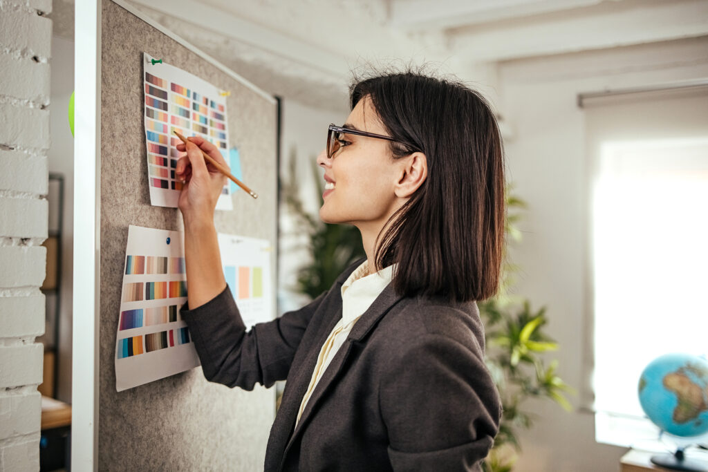 Woman standing by a blackboard looking at it and thinking. Concept of business planning