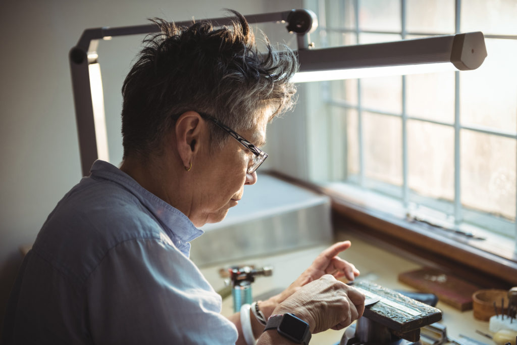 woman working at a work bench in front of window