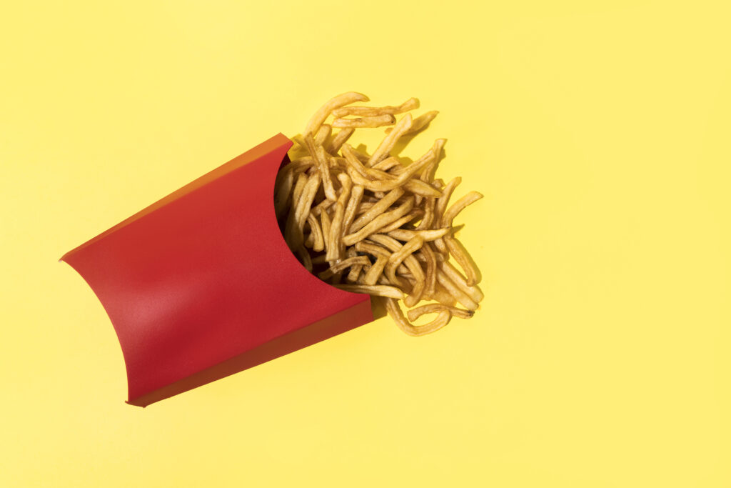 Elevated View Of French Fries On Yellow Background: Brand colors.