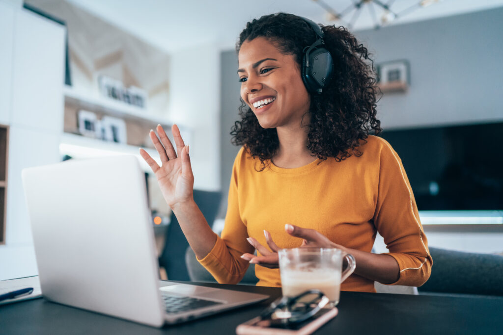 Young modern woman having Video Conference at home. One of the tips for virtual meetings: look at the camera. 