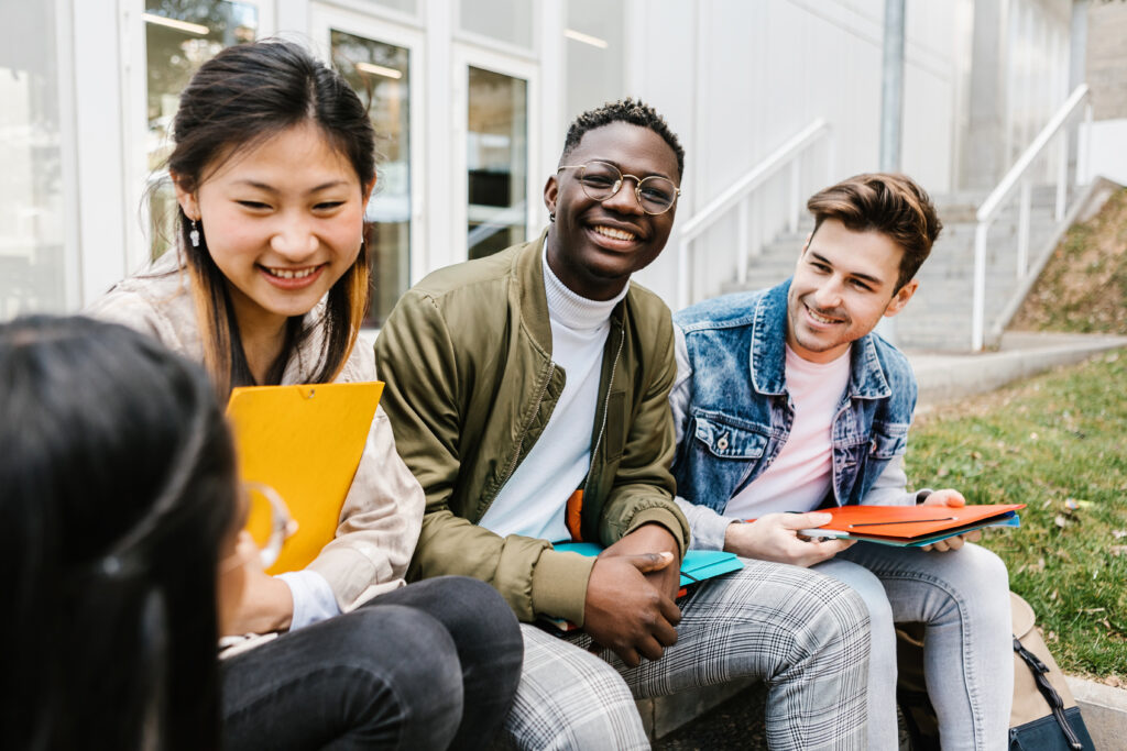 Multiracial group of young teenage people hanging out at university campus