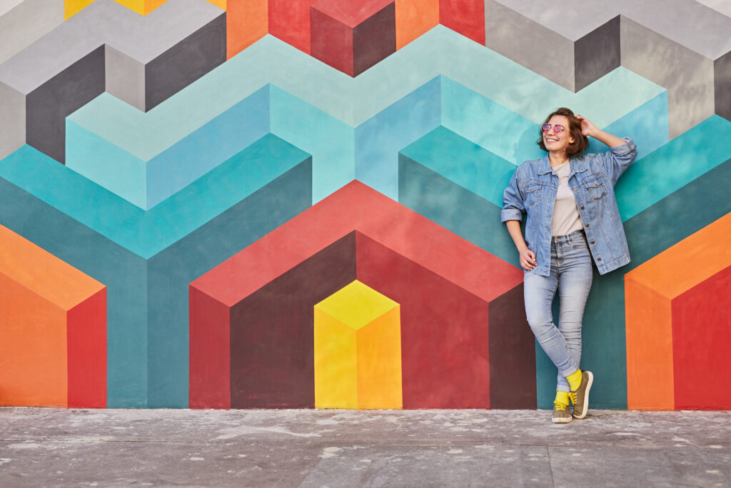 Young woman leaning on colorful wall