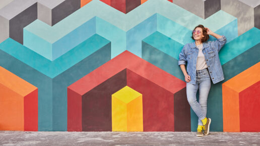 Young woman leaning on colorful wall