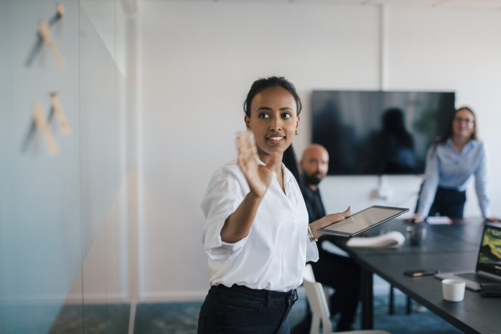 Businesswoman brainstorming over adhesive notes in meeting at board room