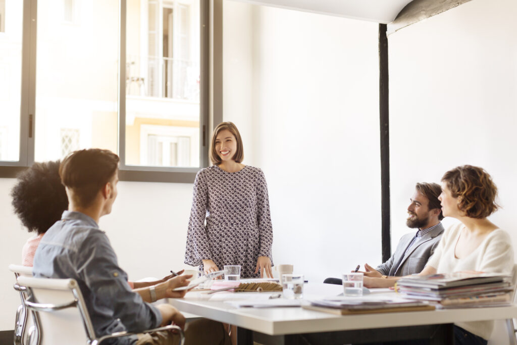 Smiling young businesswoman giving presentation to colleagues in office. Effective presentation strategy