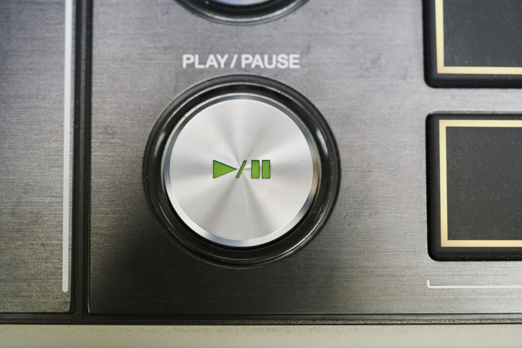 Close-up of the play/pause button of a sound mixer console in a broadcast room