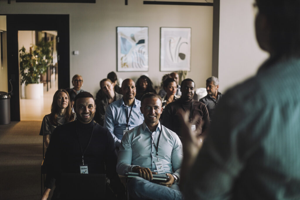 An audience of people watching someone present