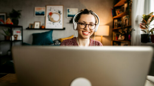 Young woman teaching online from her living room. Young woman wearing headphones while having a online training at home.