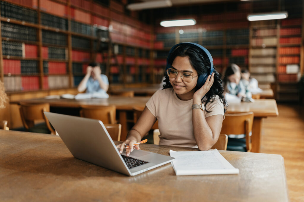 Female Indian student working on the laptop in the university library