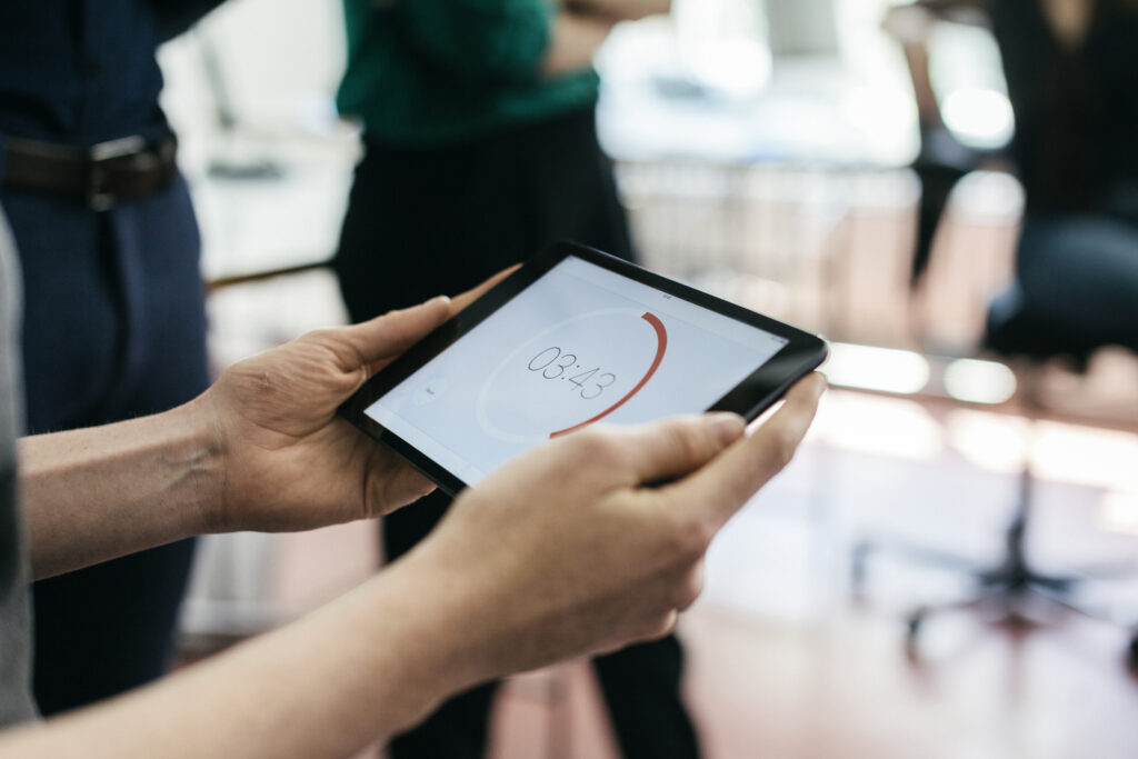 A man holding a timer on a digital tablet during a start up business meeting.