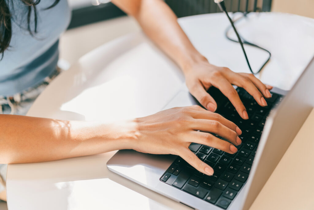 A close-up of a female entrepreneur using laptop for business and finances to work with personal data. She is utilizing AI, A.I., and ML technologies in daily life to enhance her working routine. Embracing the futuristic union of human and technology and meeting presentation deadlines.