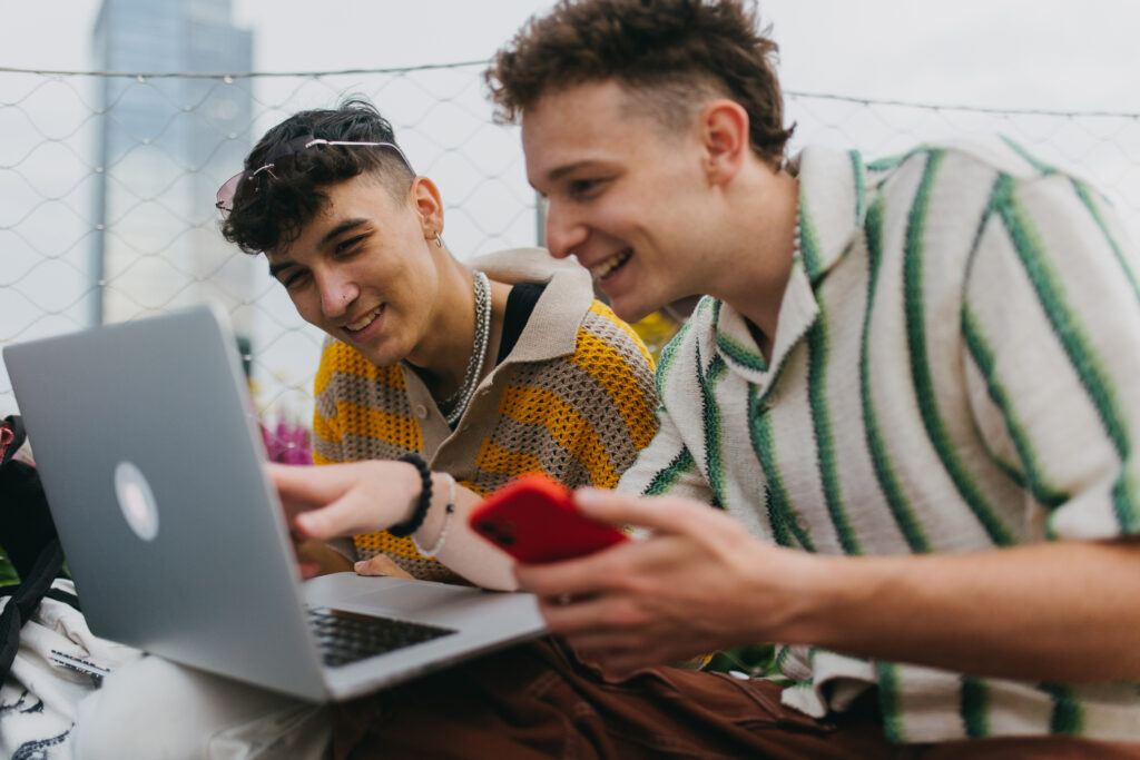 Generation Z students studying together outdoors after school. Young stylish zoomers working together on school project, preparing a presentation. Concept of power of friendship and importance of education for gen Z.