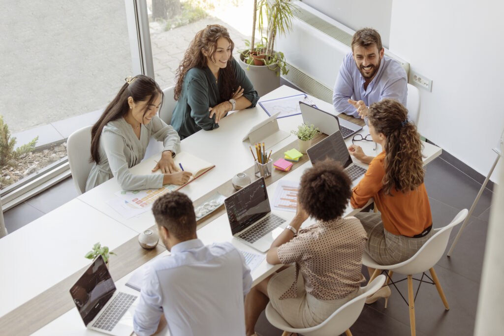 Diverse business people discussing together while having a meeting around a table in a modern office.