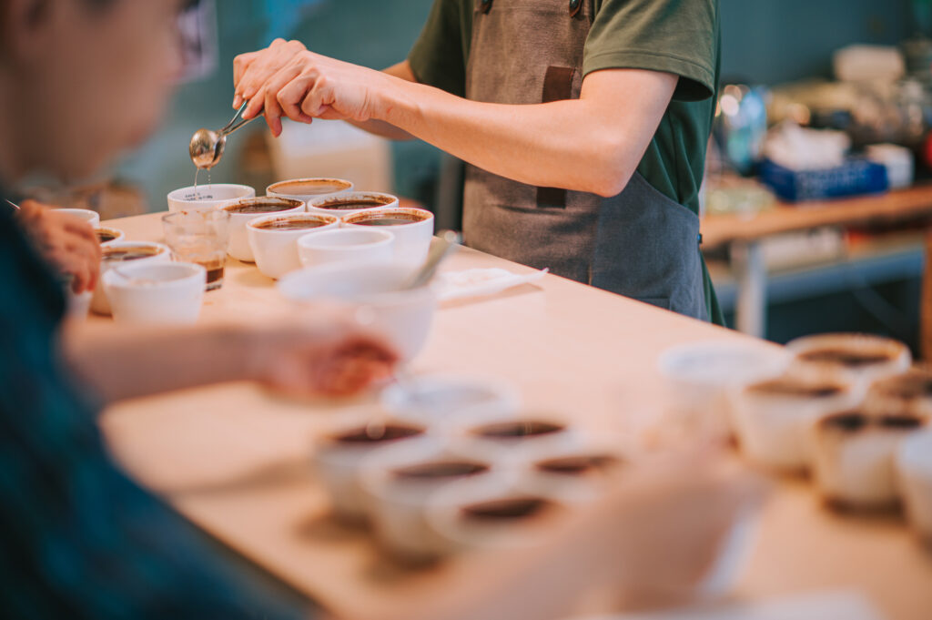 close up Asian Chinese barista connoisseur scooping coffee ground cleaning for coffee cupping tasting scope