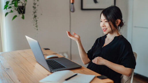 Professional and beautiful young Asian woman having a presentation over video call using laptop in the living room. Mother working from home.