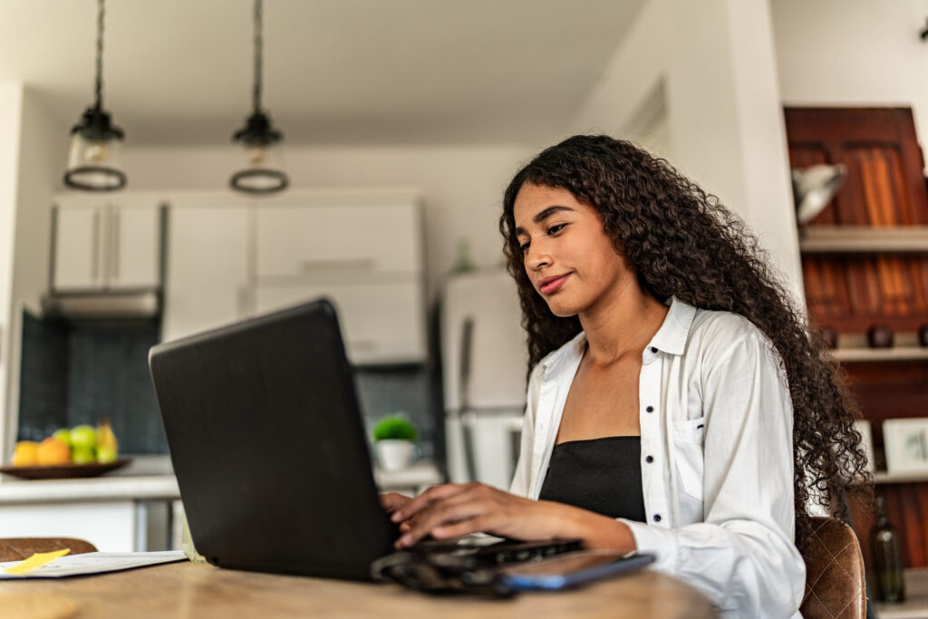 Young woman studying using laptop at home