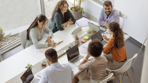 Diverse business people discussing together while having a meeting around a table in a modern office