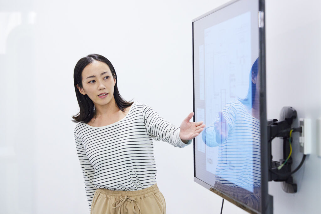 She is giving a presentation on the ongoing robotics development program.